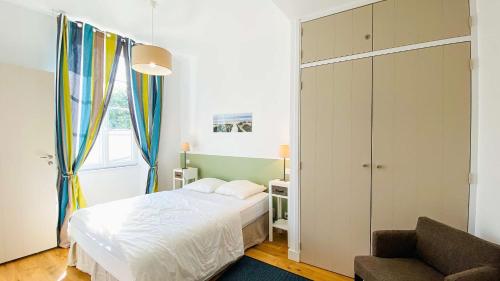 a small bedroom with a bed and a couch at Superbe appartement en plein centre village in Saint-Martin-de-Ré
