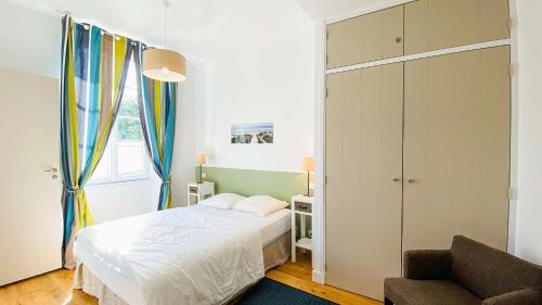 Un dormitorio pequeño con una cama y un sofá. en Superbe appartement en plein centre village, en Saint-Martin-de-Ré