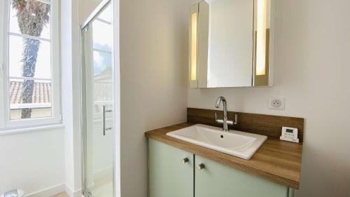 a bathroom with a sink and a window at Superbe appartement en plein centre village in Saint-Martin-de-Ré