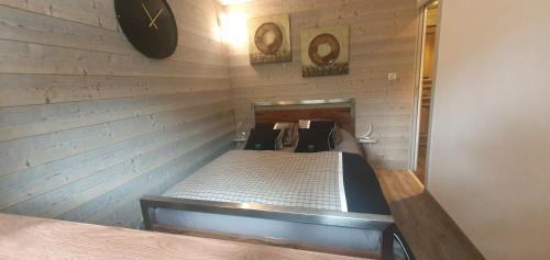 a room with a bed in a wall with a clock at RESIDENCE LE PACHA Courchevel 1850 in Courchevel