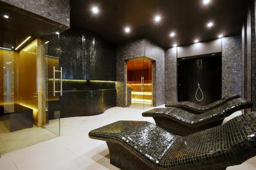 baño con 2 taburetes negros y sofá en Apartament Słoneczny Lux - Resort AQUA POLANKI - Baseny-Sauny-Siłownia-2023r en Kołobrzeg