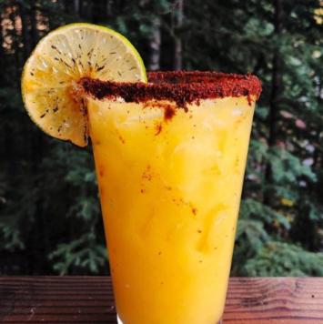 a drink with a slice of lemon on a table at McKinley Creekside Cabins in McKinley Park