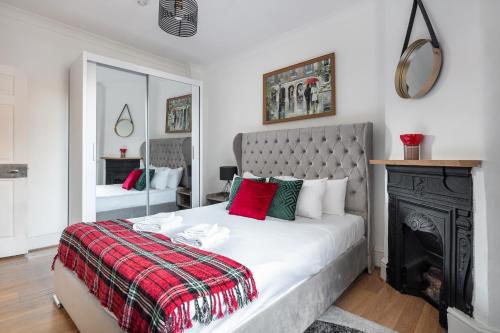 um quarto com uma cama grande e uma lareira em Gorgeous One Bed in the Heart of Central London em Londres