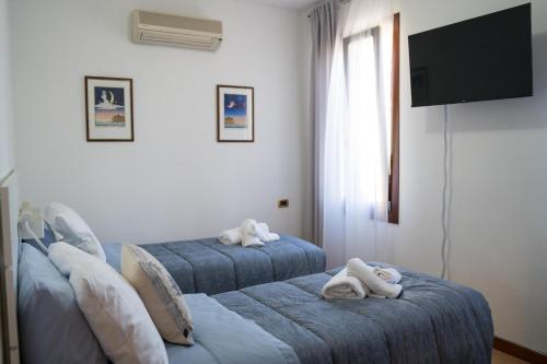 1 dormitorio con 2 camas azules y toallas. en All’Altana b&b apartment en Marghera