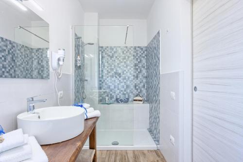 a white bathroom with a sink and a shower at LANTERNA DEL DELTA Guest House in Porto Tolle