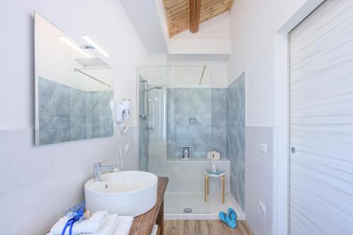 a white bathroom with a sink and a shower at LANTERNA DEL DELTA Guest House in Porto Tolle