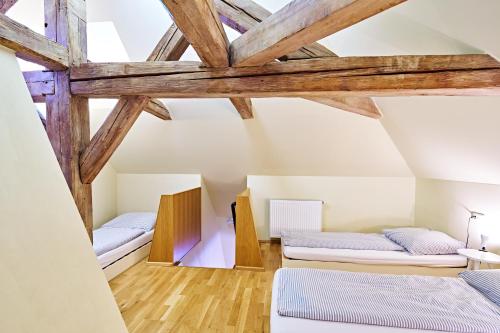 two beds in a room with wooden beams at Penzion Lípa in Krásná Lípa