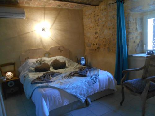 une chambre avec un lit avec des serviettes dessus dans l'établissement Gîte avec jacuzzi privatif dans un mas provençal, à Les Fumades-Les Bains