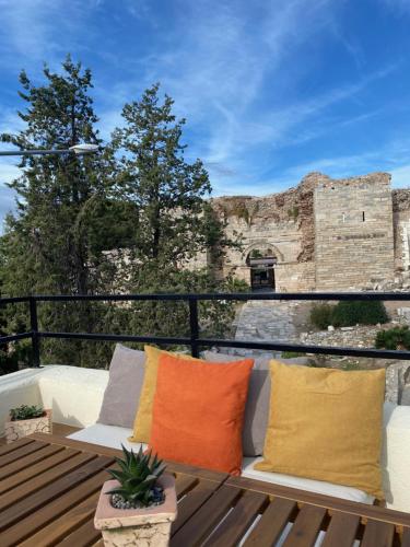 a balcony with pillows and a view of a castle at Kallinos Boutique Hotel in Selcuk