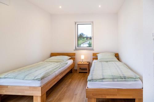 2 Einzelbetten in einem Zimmer mit Fenster in der Unterkunft Fichte in Ravensburg