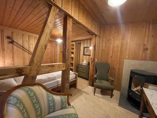 a log cabin bedroom with a fireplace and a chair at Berghotel Gasterntal in Kandersteg