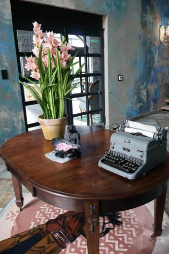 einen Tisch mit einer Schreibmaschine und einer Pflanze darauf in der Unterkunft 360 Country Hotel in Clarens