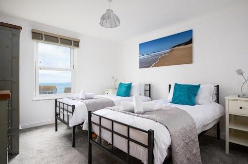 - une chambre avec 2 lits et une fenêtre donnant sur la plage dans l'établissement 8 Spinnakers, à Newquay