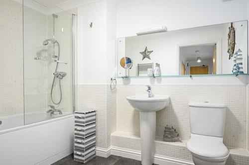 La salle de bains est pourvue d'un lavabo, de toilettes et d'une douche. dans l'établissement 8 Spinnakers, à Newquay