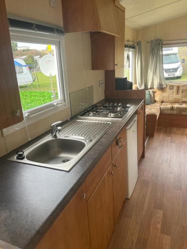 a kitchen with a sink and a stove at CHALETS IN THE DUNES nearby the beach in IJmuiden