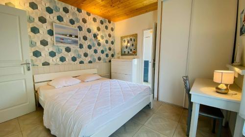 Schlafzimmer mit einem Bett, einem Tisch und einem Schreibtisch in der Unterkunft Villa récente avec accès à la plage par chemin à l'arrière de la maison in Le Bois-Plage-en-Ré