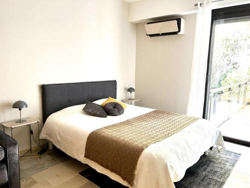um quarto com uma cama e uma grande janela em Super Cannes appartement 40m2, piscines tennis em Vallauris