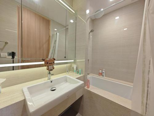 a bathroom with a sink and a mirror and a tub at 小憩 屋顶无边泳池 terminal21 Phrom phong Asok 21航站楼 阿索 in Bangkok