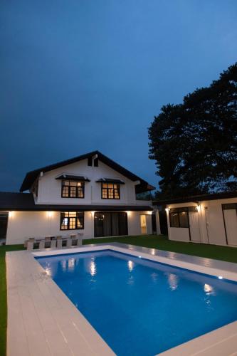 a swimming pool in front of a house at night at Number3 Poolvilla Bangkok in Lat Krabang