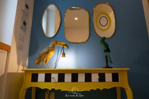a wall with mirrors and a bird on a table at LA CASA DI ZOE in Manfredonia