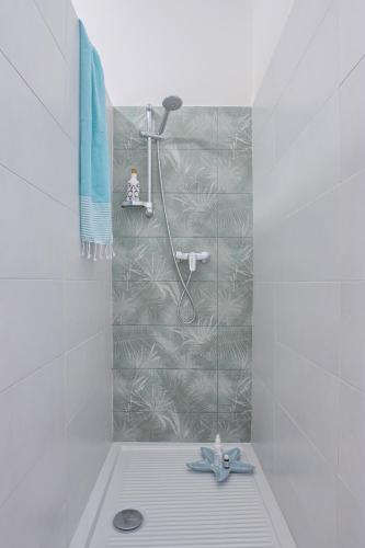 a white bathroom with a shower with a tile wall at LANTERNA DEL DELTA Guest House in Porto Tolle