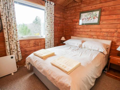 a bedroom with a bed in a log cabin at Strathconon in Acharacle