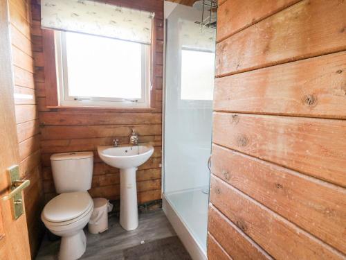 La salle de bains est pourvue de toilettes, d'un lavabo et d'une fenêtre. dans l'établissement Strathconon, à Acharacle