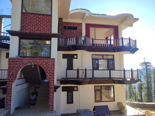 a large house with a balcony on the side of it at Norvin Homes in Shimla