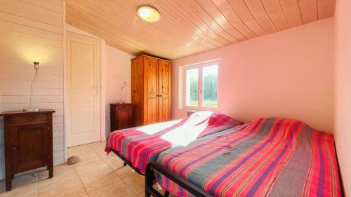 Schlafzimmer mit einem Bett und einem Fenster in der Unterkunft Ensemble de 2 maisons dans les dunes in Le Bois-Plage-en-Ré
