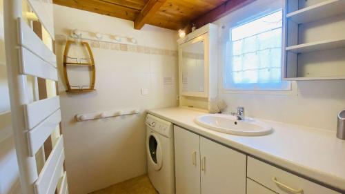 ein Badezimmer mit einem Waschbecken und einer Waschmaschine in der Unterkunft Ensemble de 2 maisons dans les dunes in Le Bois-Plage-en-Ré