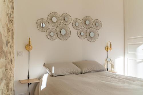 Un dormitorio con una cama con cuatro espejos en la pared. en Le plus beau balcon des Arènes, en Nimes