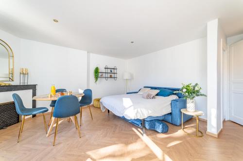 une chambre avec un lit, une table et des chaises dans l'établissement Le plus beau balcon des Arènes, à Nîmes