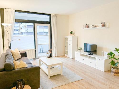 a living room with a couch and a tv at Waldoase I inkl Sauna-und Schwimmbadnutzung in Bad Harzburg