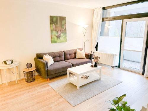 ein Wohnzimmer mit einem Sofa und einem Tisch in der Unterkunft Waldoase I inkl Sauna-und Schwimmbadnutzung in Bad Harzburg