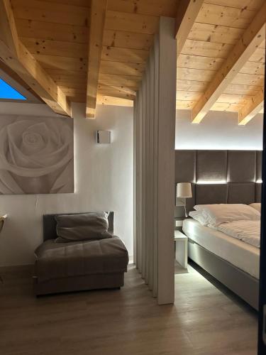 a bedroom with a bed and a ottoman in it at ROSENSUITE La Residenza del rosengarten in Pinzolo