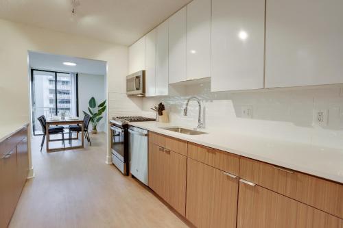 a kitchen with white cabinets and a sink at Condo Steps Away From Crystal City Metro Station in Arlington
