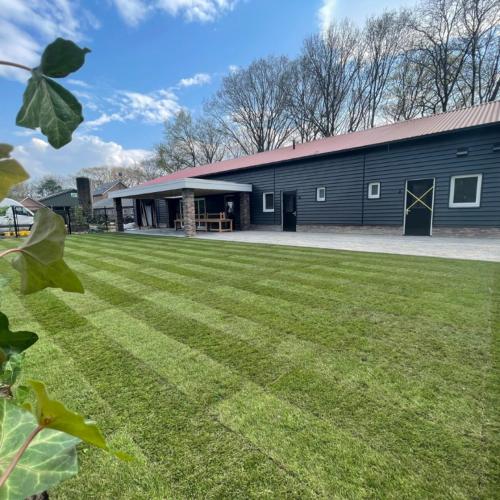 a large building with a grass field in front of it at Brabantse Nacht in Deurne