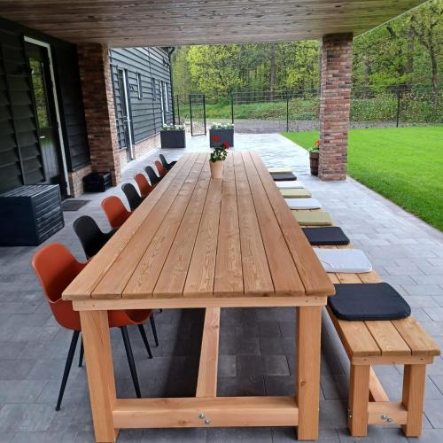 Une table et des chaises en bois sont disponibles sur la terrasse. dans l'établissement Brabantse Nacht, à Deurne