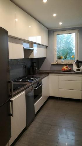 a kitchen with white cabinets and a stove and a window at Sosnowiec przy placu in Sosnowiec
