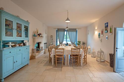 a kitchen with a dining table and blue cabinets at Trullisia Bed and Breakfast in Alberobello