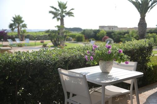 a white table with a vase of flowers on it at BdL Open Space in Marsala