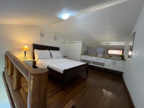 1 dormitorio pequeño con 1 cama y cocina en Loft encantador em Praia do Forte próximo à Vila., en Praia do Forte