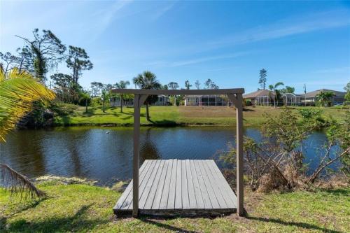 a wooden bench sitting next to a body of water at Seabreeze 3-Bedroom Pool Villa close to the beach!!! in Port Charlotte