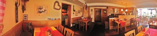 a room with a restaurant with a table and chairs at Zur neuen Post Landgasthof in Herzogsreut