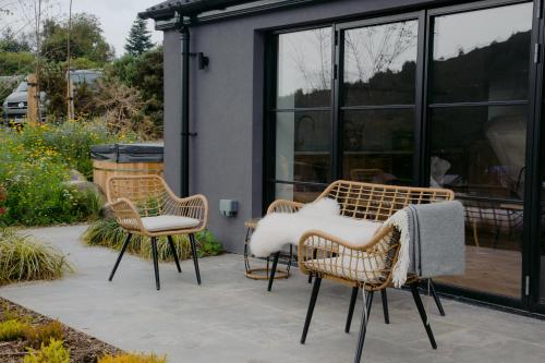 three chairs and a table on a patio at The Deerstone Luxury Eco Hideaway in Laragh