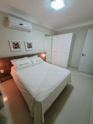 a bedroom with a large white bed with white cabinets at Apartamento Summer Beach Bombas in Bombas
