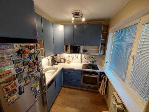 una cucina con mobili blu e un frigorifero di Sääse 3 Apartment a Tallinn