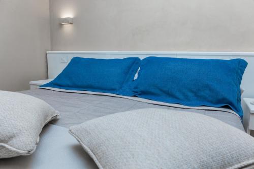 a bed with two blue pillows on top of it at EUROPA Hotel in Vasto