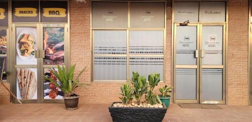 een gebouw met deuren en planten ervoor bij Great Heights Motel in Entebbe
