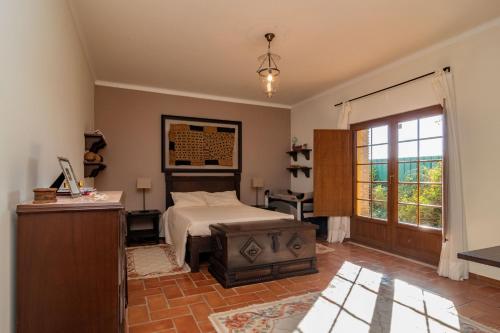 a bedroom with a bed and a desk and a window at Villa with Pool & private garden - Palmela Quinta das Oliveiras in Pinhal Novo